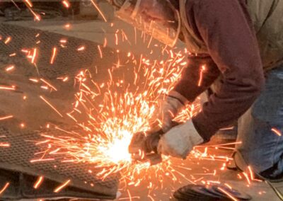 american rigging & millwright service - millwright wearing ppe working with metal sparks
