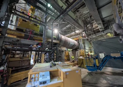 Maintenance crew servicing large industrial machinery inside manufacturing facility