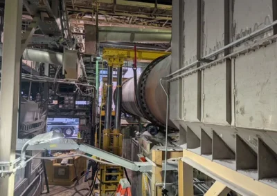 Industrial maintenance work being performed on large equipment inside manufacturing plant